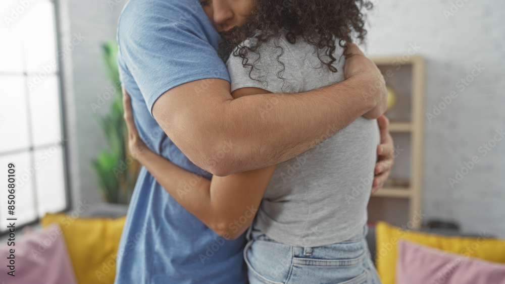 A loving couple embraces warmly in a cozy living room, depicting affection and a comfortable home environment. A loving couple embraces warmly in a cozy living room, depicting affection and a comfortable home environment.