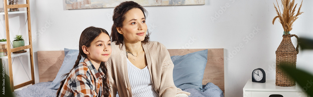 A woman sitting close to a young girl on a cozy bed, sharing heartfelt moments together at home. A woman sitting close to a young girl on a cozy bed, sharing heartfelt moments together at home.