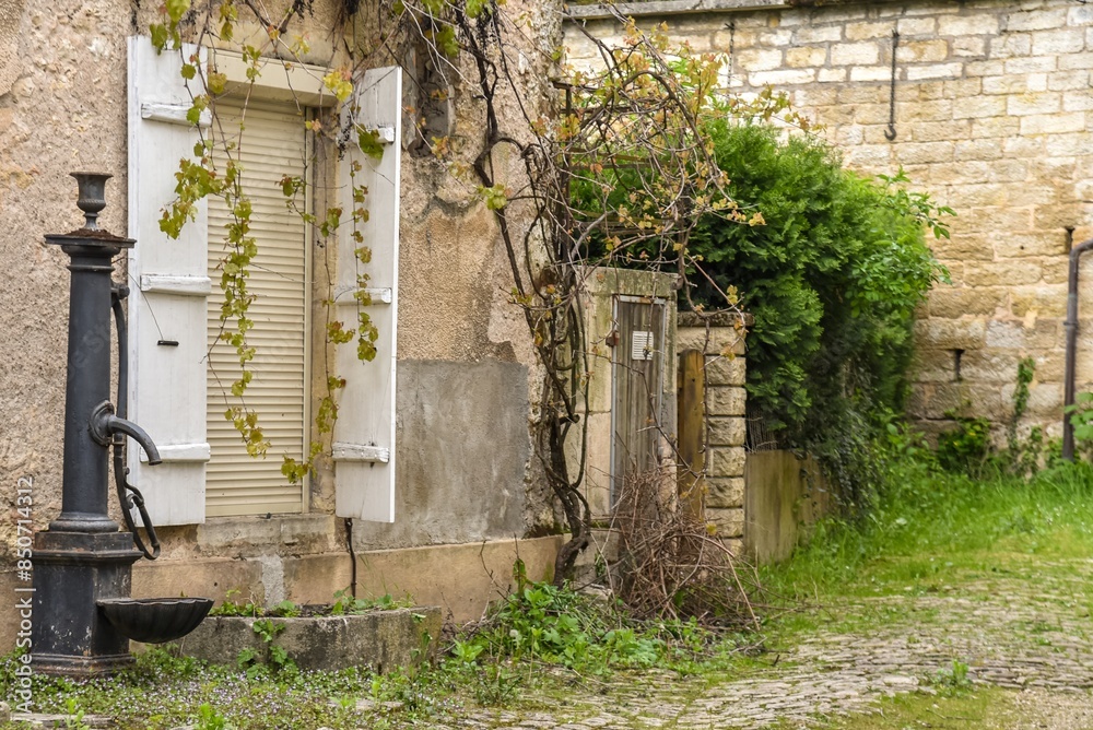 entrance of an old house with a vintage water pump