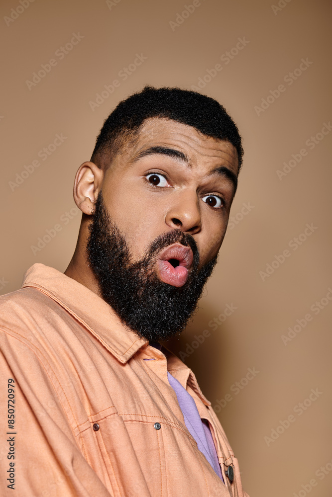 Handsome African American man looks surprised in trendy clothing against colorful background. Handsome African American man looks surprised in trendy clothing against colorful background.