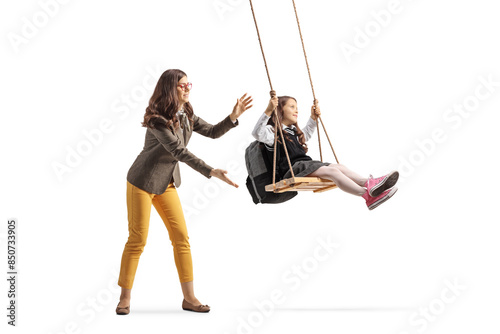 Woman pushing a schoolgirl on a swing