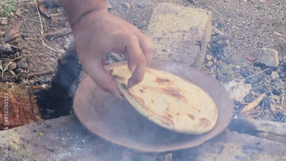 Jowar Roti or Indian bread, making process on Rural kitchen using bio wood fuel for cooking. Gujarati traditional sorghum ki roti or pearl millet flat bread. lunch which are bajre ki roti