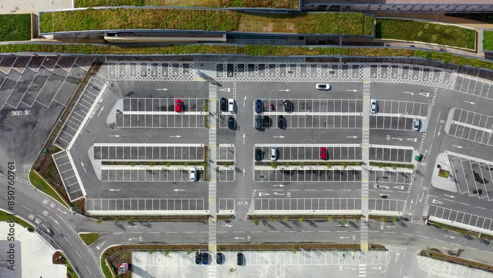 Aerial footage of a quiet car park from above showing a couple of cars driving around the car park parking lot at the Leeds Skelton Lake Services on a bright sunny summers day in the UK