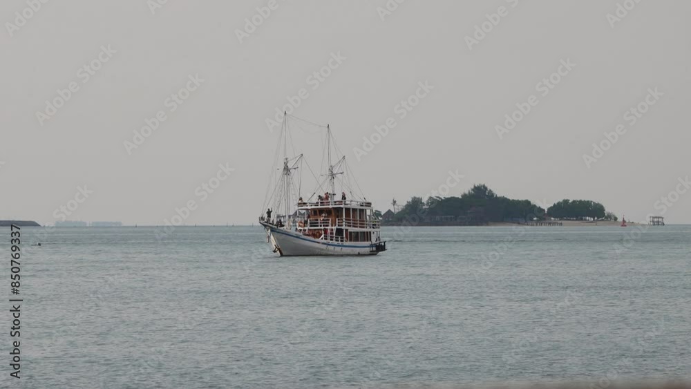 The journey of a phinisi boat sailing from an island The journey of a phinisi boat sailing from an island