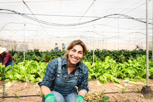 Happy Latin farmer working inside agricultural greenhouse - Farm people lifestyle concept photo