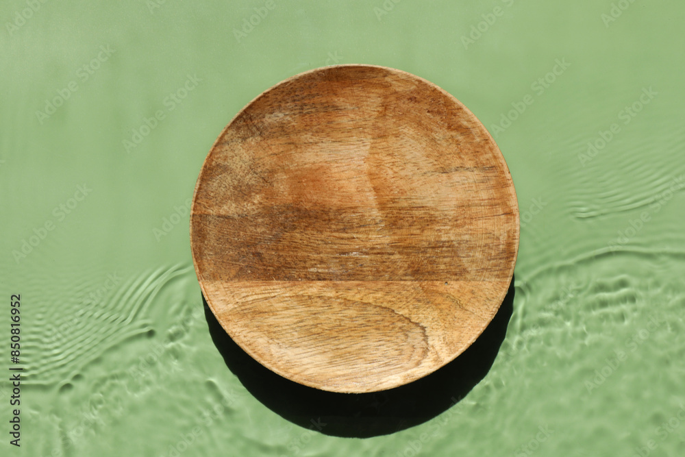 Presentation for product. Wooden podium in water on green background, top view Presentation for product. Wooden podium in water on green background, top view