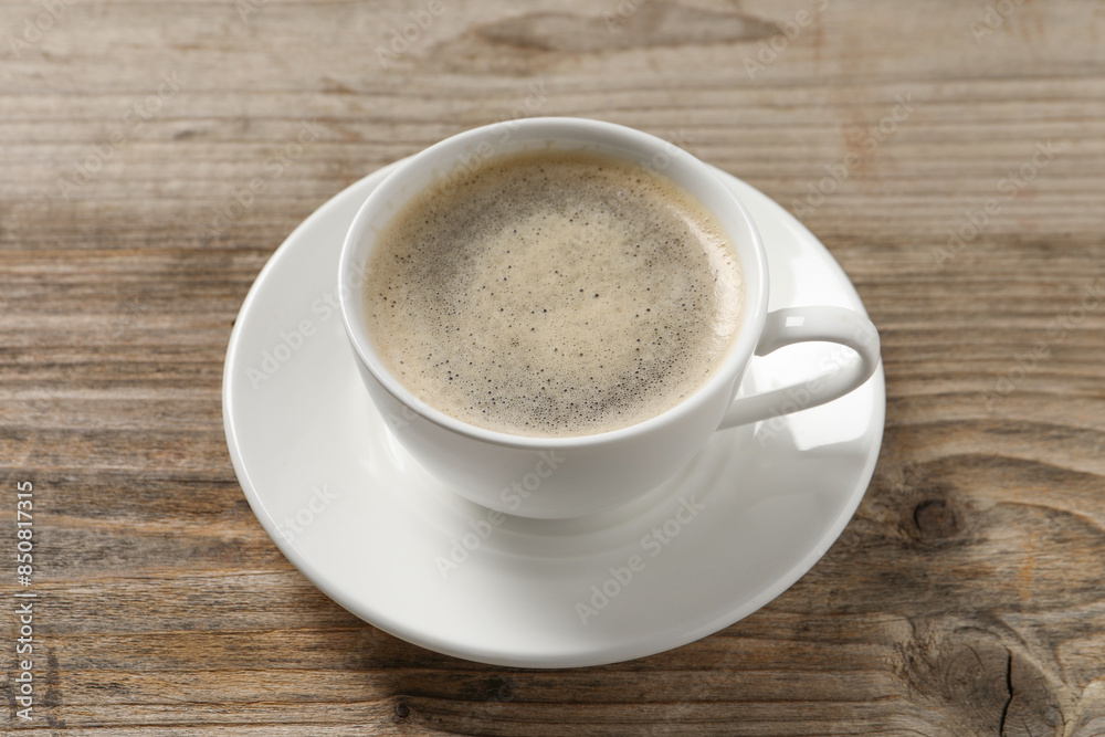 Tasty coffee in cup on wooden table, closeup Tasty coffee in cup on wooden table, closeup