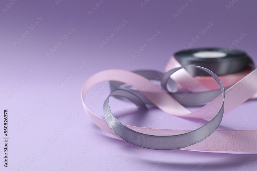 Beautiful ribbons in different colors on violet background, closeup. Space for text Beautiful ribbons in different colors on violet background, closeup. Space for text