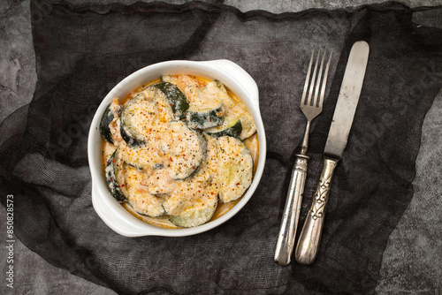 close-up baked zucchini baked with sauce in bowl