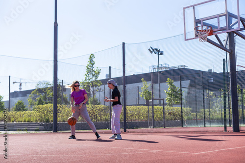 Photography Mother and daughter playing basketball.
