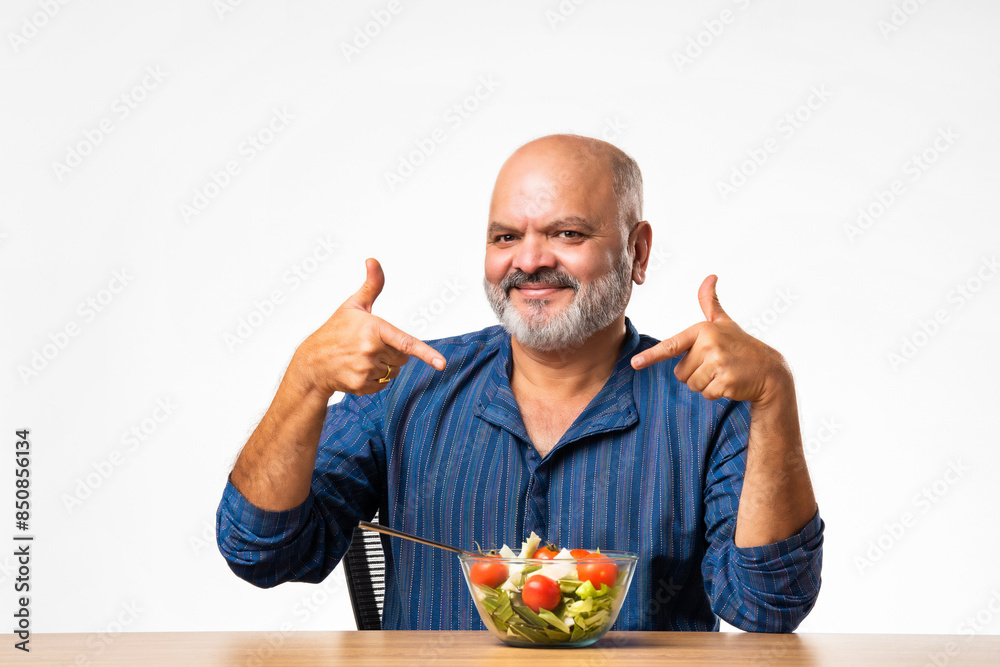 Senior Indian asian man eating fresh salad. Mature male having healthy snack, healthcare, diet concept. Senior Indian asian man eating fresh salad. Mature male having healthy snack, healthcare, diet concept.