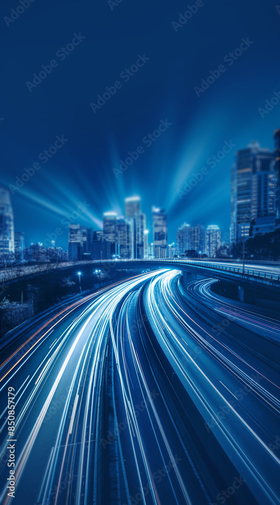 Fototapeta premium Nighttime city street with colorful light trails from moving cars. Headlights guiding the way to a towering skyline, illustrating the motion and vibrancy of the futuristic metropolis.