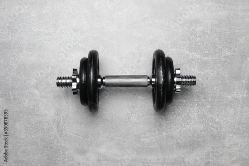 One barbell on grey textured background, top view
