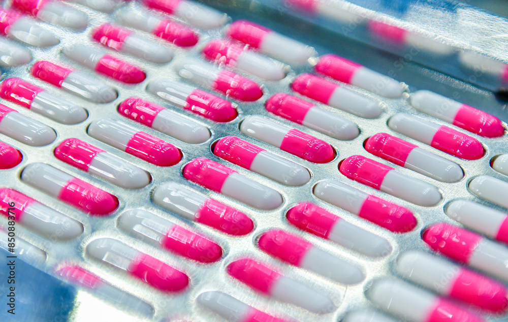 Close-up shot pink capsules are moving on the conveyor belt at Modern Pharmaceutical Factory. Close-up shot pink capsules are moving on the conveyor belt at Modern Pharmaceutical Factory.