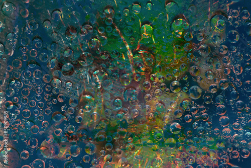 Translucent raindrops falling down against the green-blue background. Abstract fantasy. 3D render.