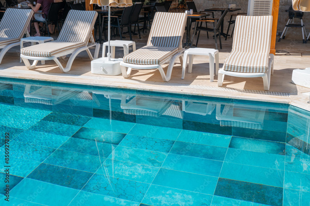 Empty swimming pool in the hotel in summer. Swimming pool with umbrella chairs in a beautiful swimming pool in a tropical resort. Empty swimming pool in the hotel in summer. Swimming pool with umbrella chairs in a beautiful swimming pool in a tropical resort.