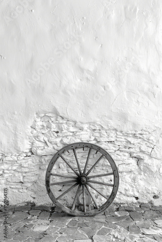 Simple shot of a Romani wagon wheel against a clean, white wall, photo