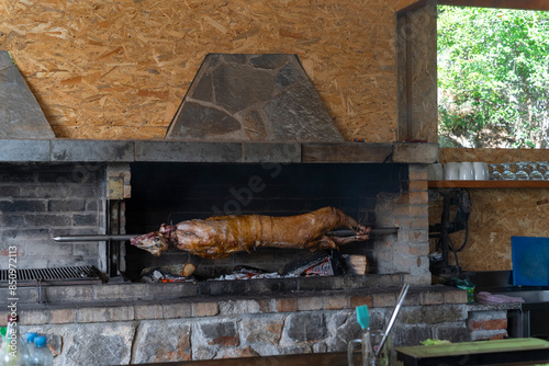 Roasted lamb on a spit over the coals of a barbecue