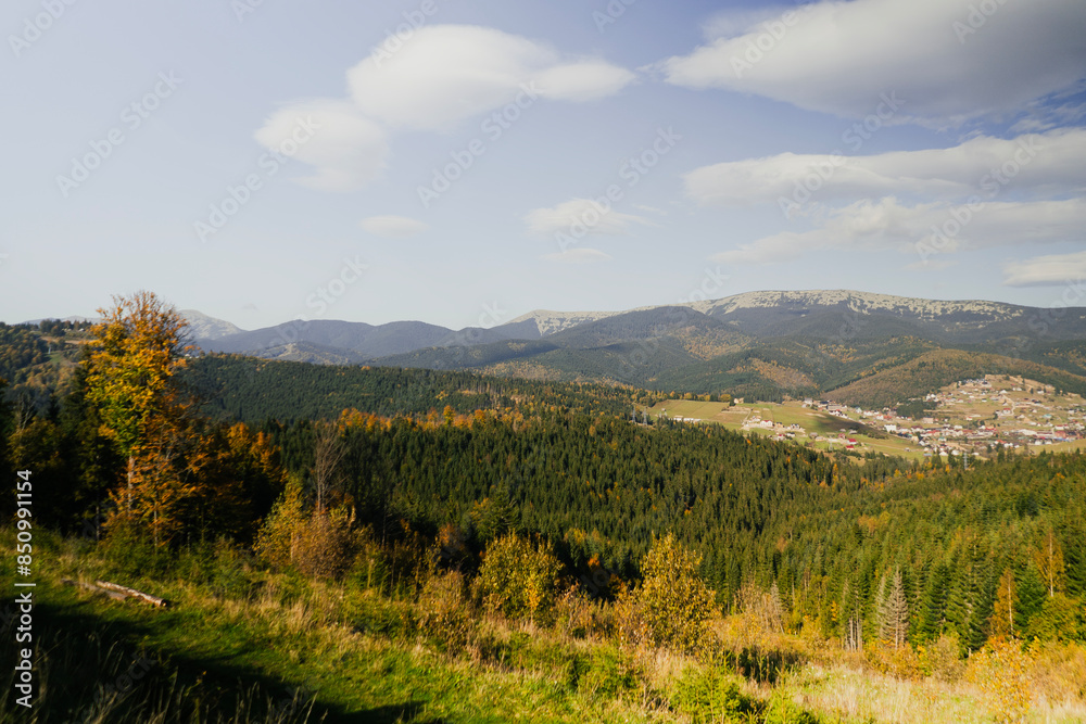 Autumn mountains with green forest and tall trees. Travel, vacation and relaxation with fresh air. View from the height of a high mountain ski resort Autumn mountains with green forest and tall trees. Travel, vacation and relaxation with fresh air. View from the height of a high mountain ski resort