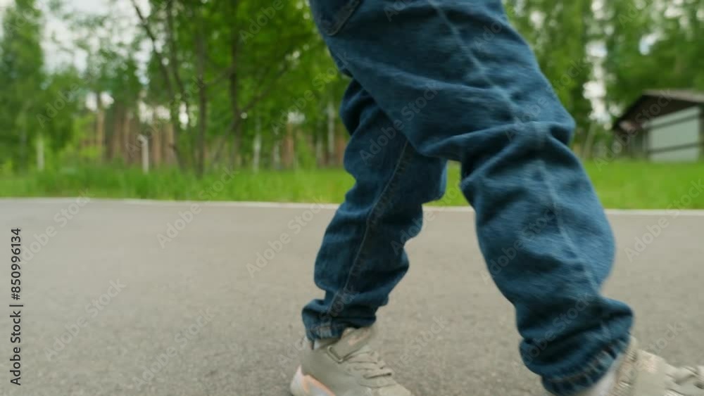 Little child girl riding a skateboard in a city park passing sideways on the path. Little child girl riding a skateboard in a city park passing sideways on the path.