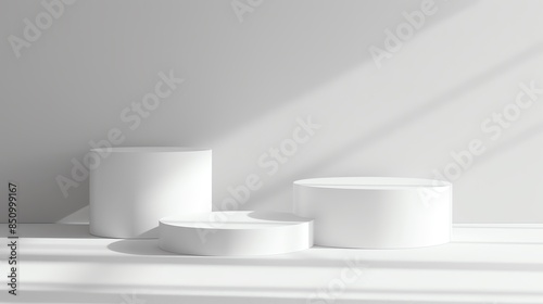 White geometric podiums arranged asymmetrically on a light grey matte background photo