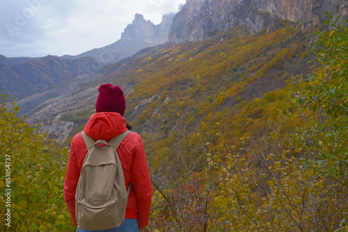 Obraz na płótnie Brunette woman with a backpack on her back outdoors exploring the Caucasus Mountains in Russia, traveling, lifestyle, hiking, active autumn holidays, hiking w salonie