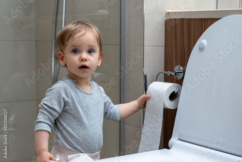 Fényképezés Toddler ripping up toilet paper in bathroom