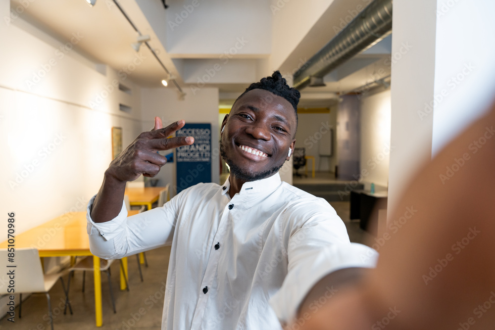 Young man taking a selfie in a modern coworking space