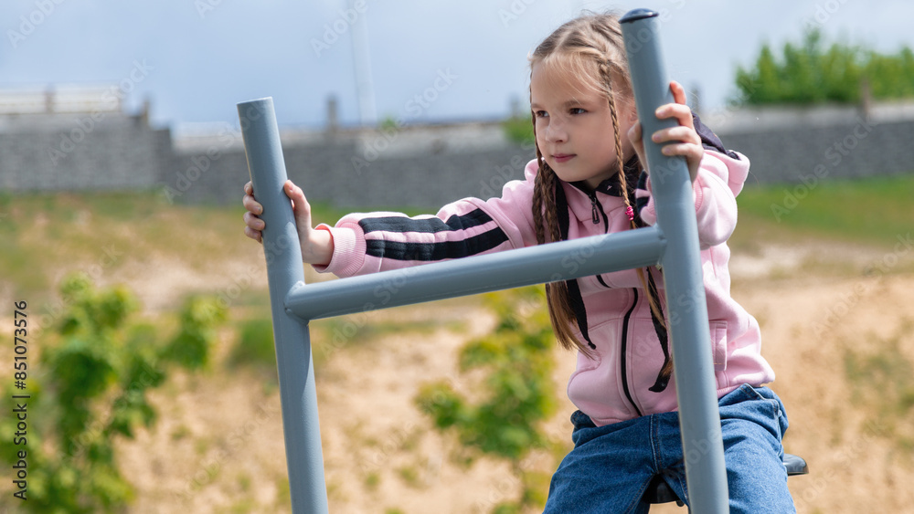 Obraz premium Sporty child girl doing morning workout on street sports ground. Fitness workout. a healthy family. street sports ground in a city park in casual clothes. Street workout