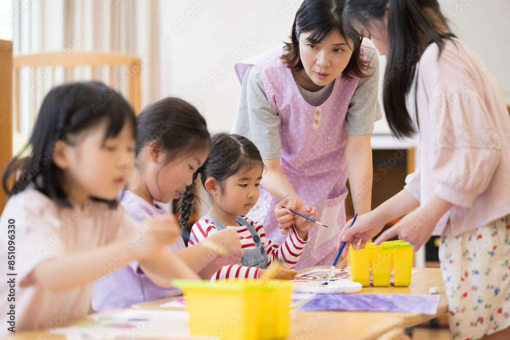 学童や放課後デイサービス等で勉強をする先生と生徒 小学生複数 学童や放課後デイサービス等で勉強をする先生と生徒 小学生複数