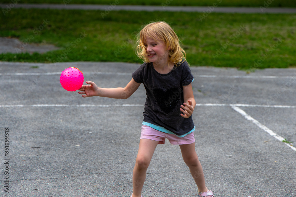 Young Girl Playing With Pink Spiky Ball on Playground Young Girl Playing With Pink Spiky Ball on Playground
