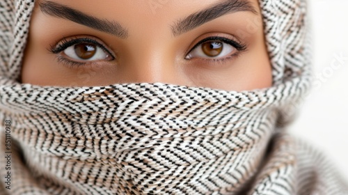 A woman with brown eyes is wearing a scarf over her face