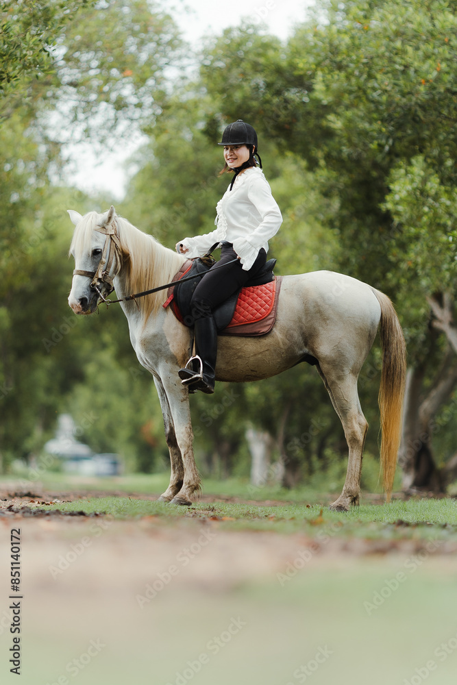 Portrait of Asia women riding horse in the farm
