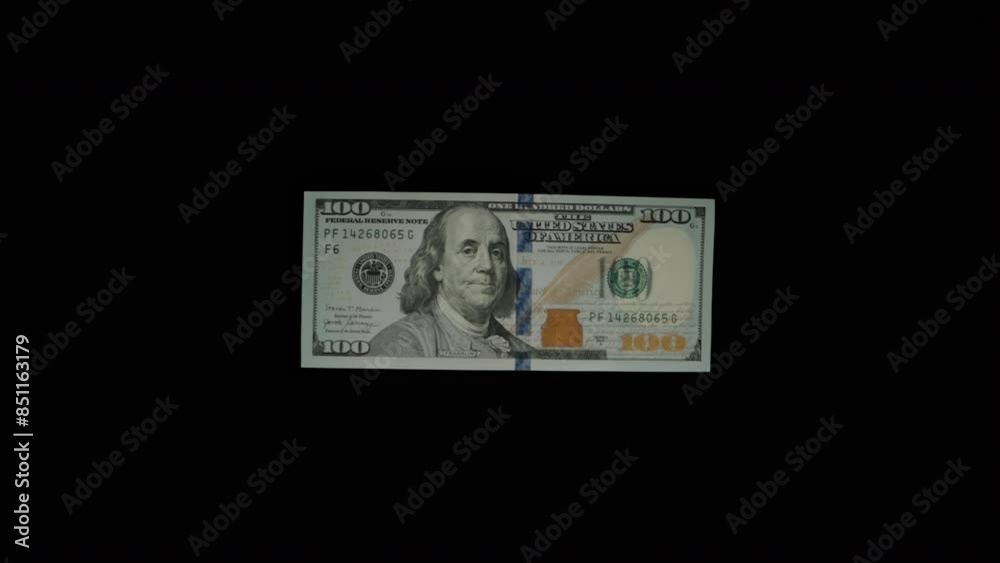 Concept Of Wasting Money. Hundred-Dollar Bills Fly Out Of A Stack One By One On A Black Background, Isolated. Slow Motion. Concept Of Wasting Money. Hundred-Dollar Bills Fly Out Of A Stack One By One On A Black Background, Isolated. Slow Motion.
