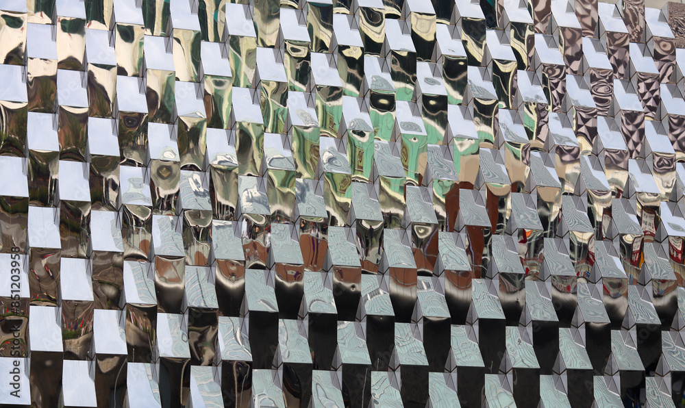 Fototapeta premium Abstract pattern of reflective silver squares. Modern metallic texture, geometric design, and industrial background with a shimmering effect
