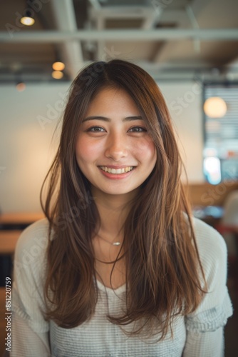 young smiling Japanese woman looking at camera in creative office