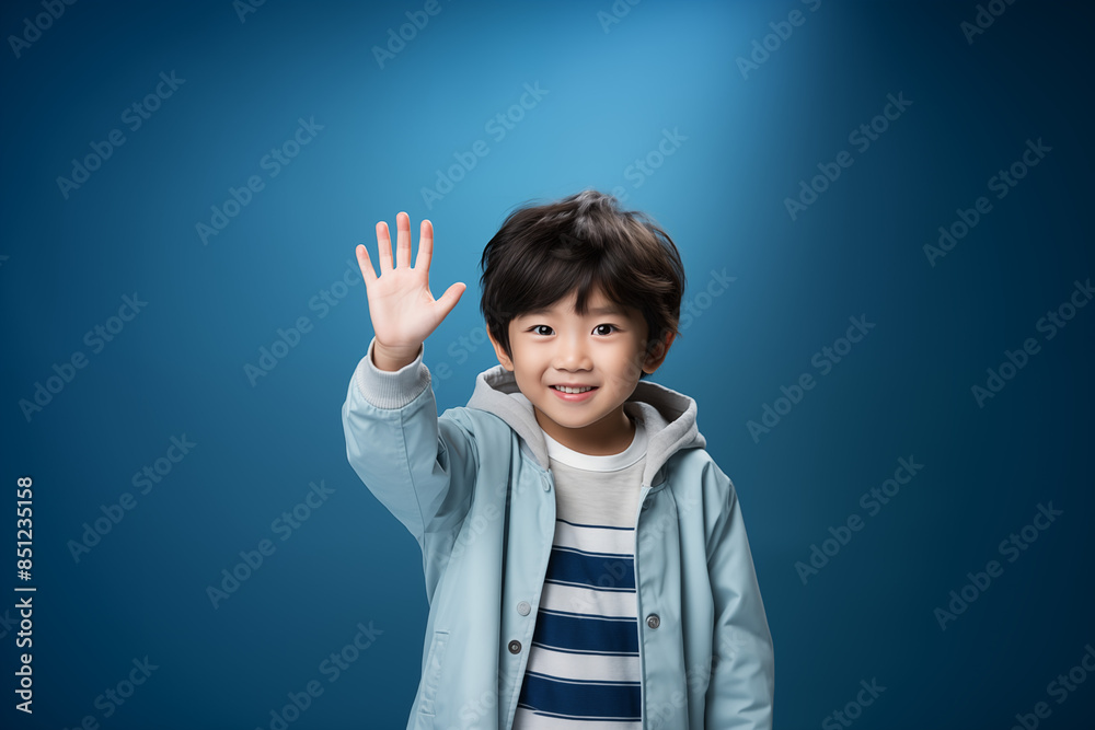 Portrait of an Asian kid wearing a blue outfit on an isolated background with copy space Portrait of an Asian kid wearing a blue outfit on an isolated background with copy space