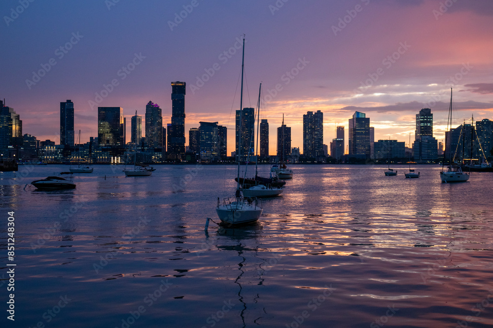 Obraz premium city skyline with boats at sunset