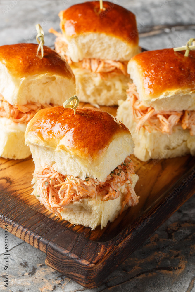 Homemade Hawaiian rolls with pulled chicken and cheese close-up on a wooden board on the table. Vertical Homemade Hawaiian rolls with pulled chicken and cheese close-up on a wooden board on the table. Vertical