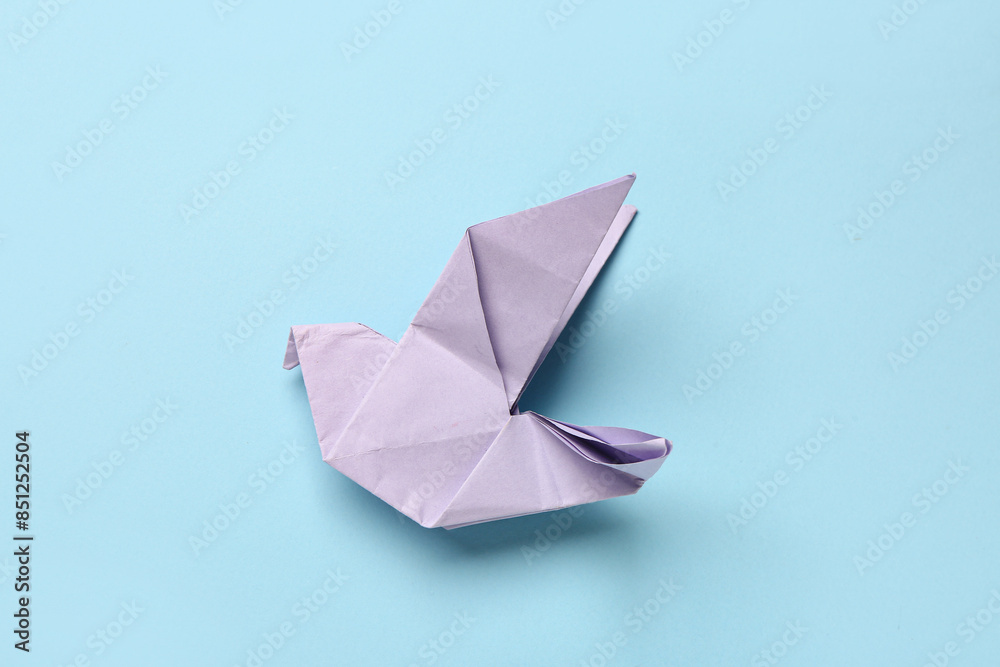 Purple origami bird on blue background Purple origami bird on blue background