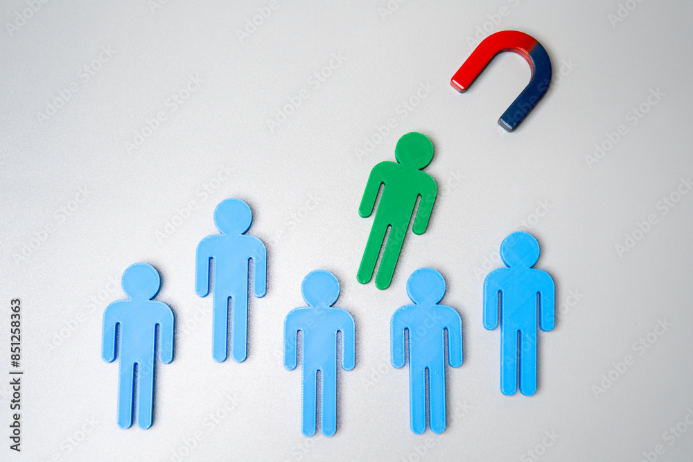 Magnet attracts human figure from the crowd. Talent acquisition, hiring and recruitment concept. Magnet attracts human figure from the crowd. Talent acquisition, hiring and recruitment concept.