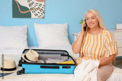 Senior woman packing suitca...