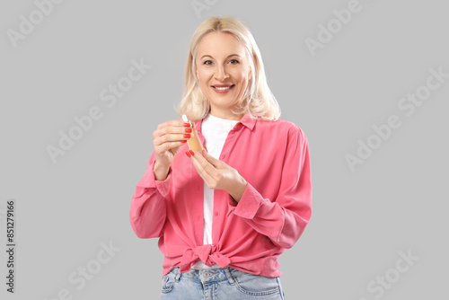 Mature woman with bottle of...