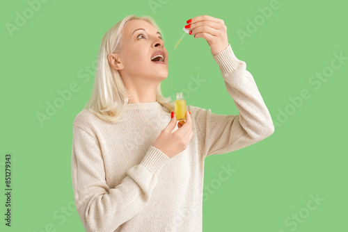 Mature woman taking CBD oil...