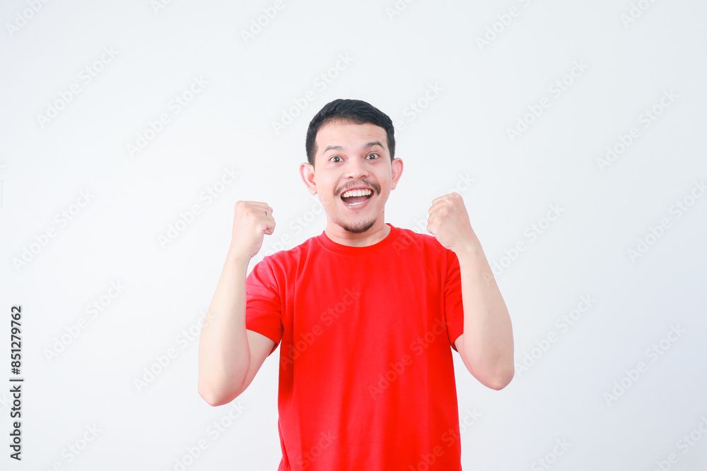 Very happy young asian man victor. clenched hands and raised, isolated in gray background. Very happy young asian man victor. clenched hands and raised, isolated in gray background.