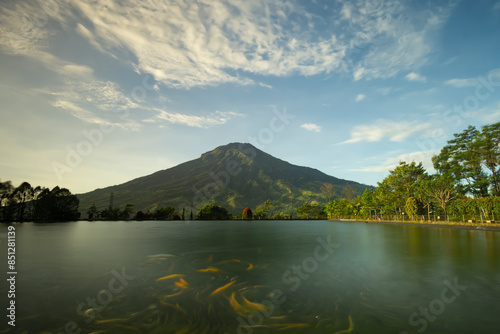 landscape view of mount sumbing sindoro in embung kledung temanggung central java indonesia with an artificial lake and swimming fish suitable for background wallpaper notes and design photo