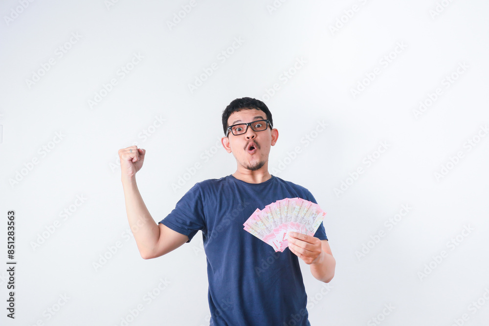 Excited young handsome Asian man holding bunch of money banknotes isolated on white background Excited young handsome Asian man holding bunch of money banknotes isolated on white background