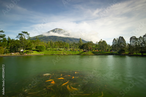 landscape view of mount sumbing sindoro in embung kledung temanggung central java indonesia with an artificial lake and swimming fish suitable for background wallpaper notes and design photo