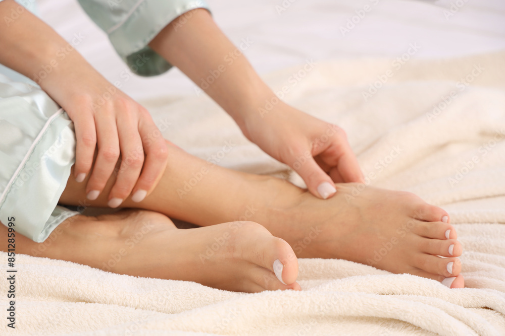 Woman making foot massage on bed in bedroom, closeup Woman making foot massage on bed in bedroom, closeup