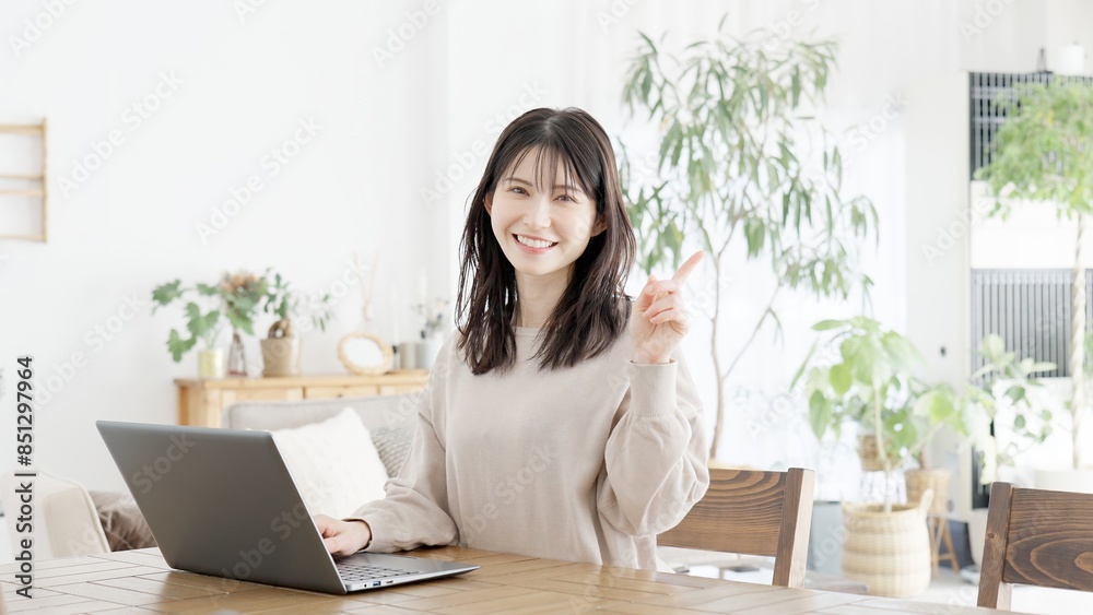 パソコンを使いながら指差しをする女性 パソコンを使いながら指差しをする女性